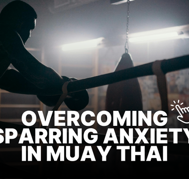 Man in dimly lit Muay Thai gym, resting on the ropes after sparring. 