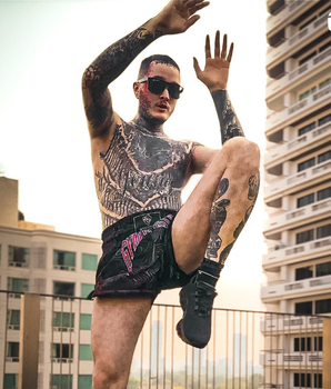 Man throwing knee in GYM NASTY Muay Thai mode shorts