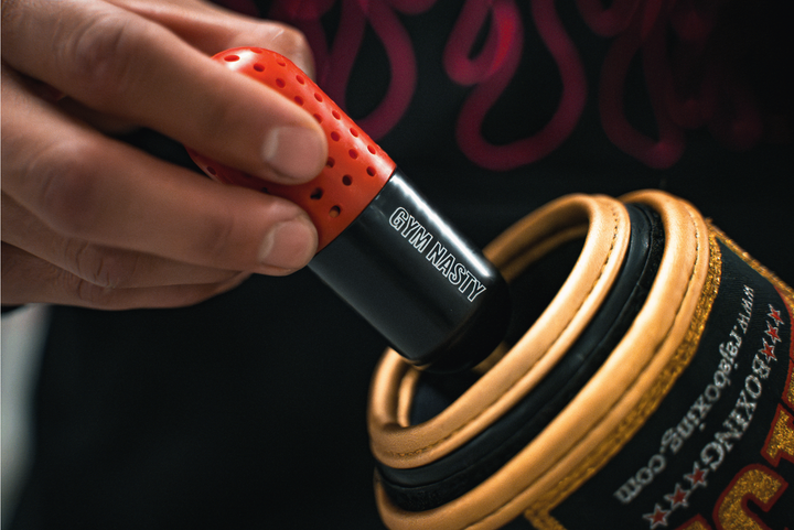 Hand holding black and red boxing glove deodoriser - Close up